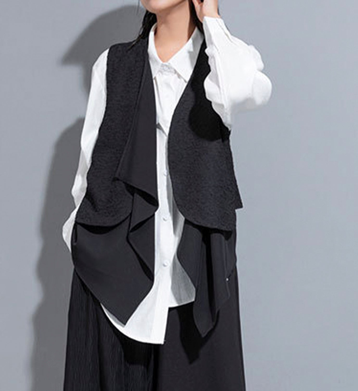 Black layered vest from DIGS featuring multiple fabric panels and a stylish, modern design.