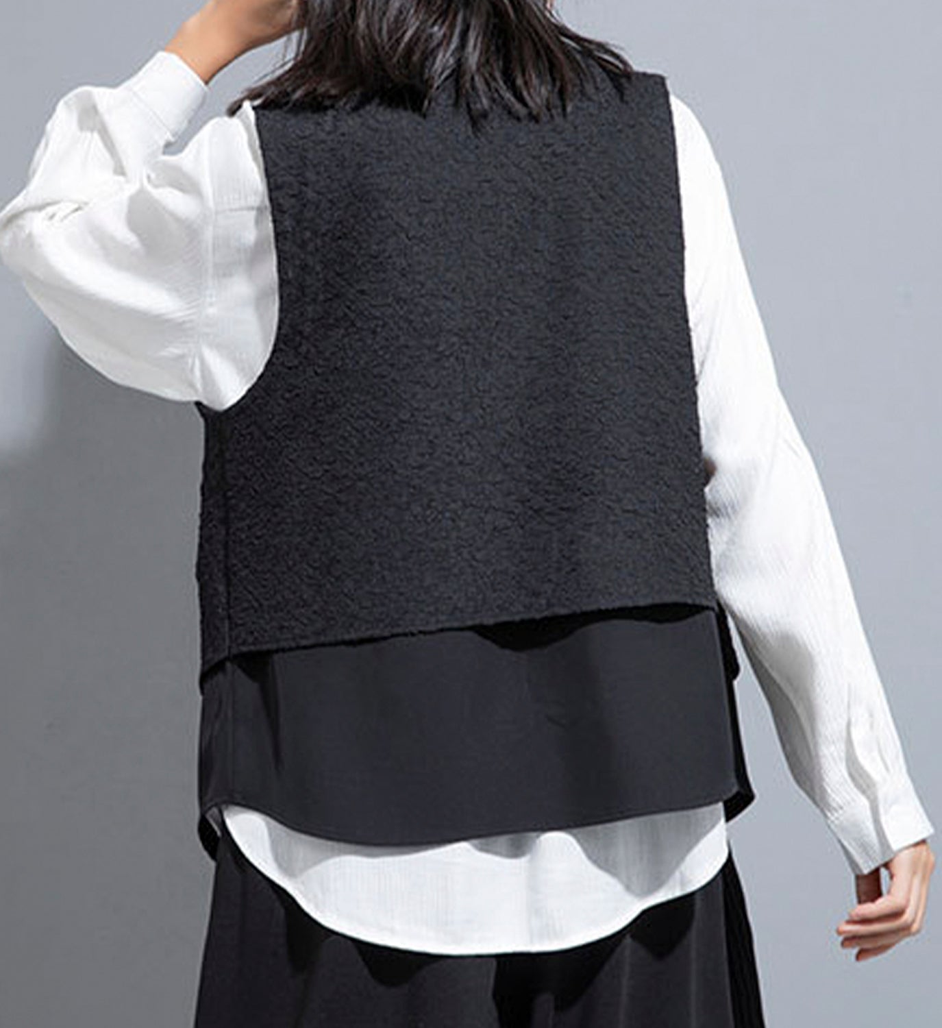 Stylish layered vest by DIGS featuring a modern design with visible textured fabric and a layered front for versatile fashion.